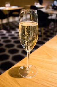 You can order anything from the bar at the dining room tables as well. Try the champagne!
